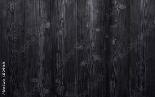Background of old vintage black wooden boards. Strongly worn and scratched.