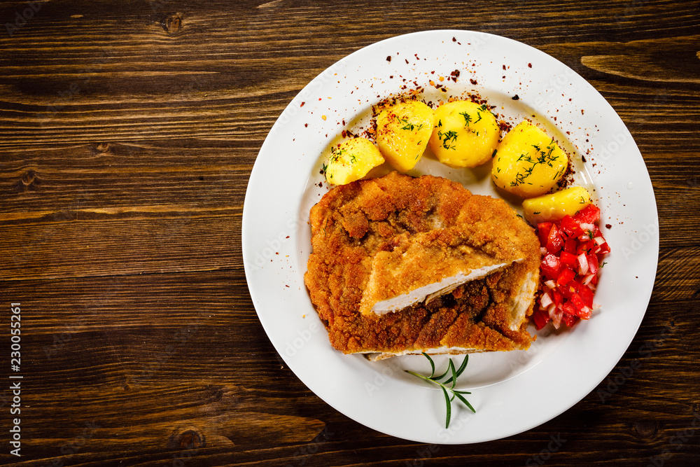 Fried pork chop, boiled potatoes and vegetable salad Fried pork chop, boiled potatoes and vegetable salad