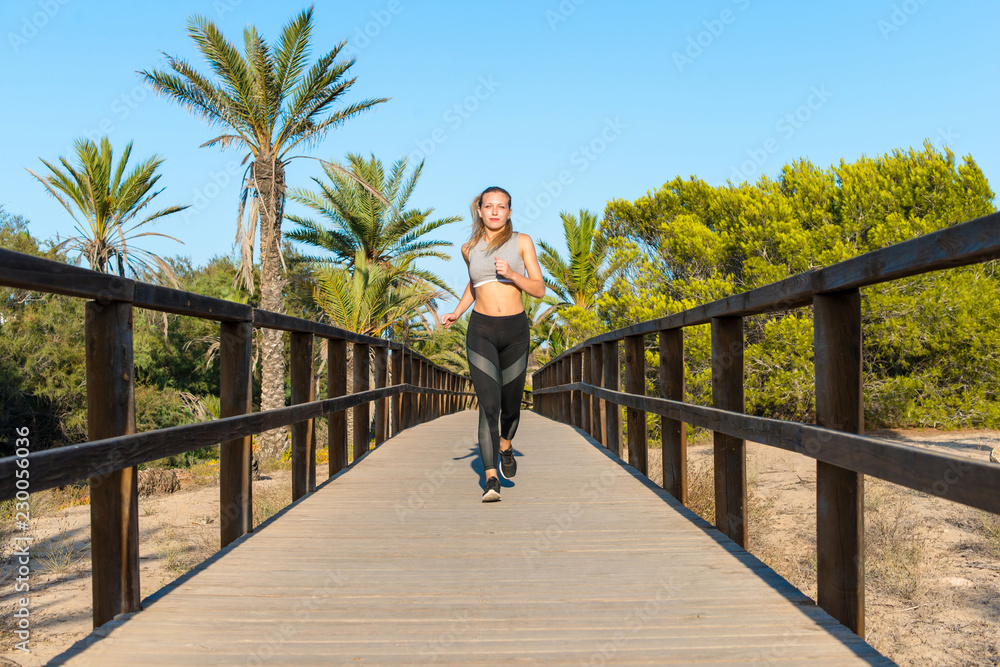 Young sport woman doing exercise and running in the park