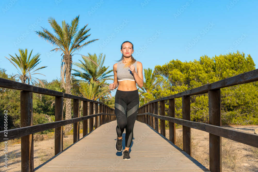 Young sport woman doing exercise and running in the park