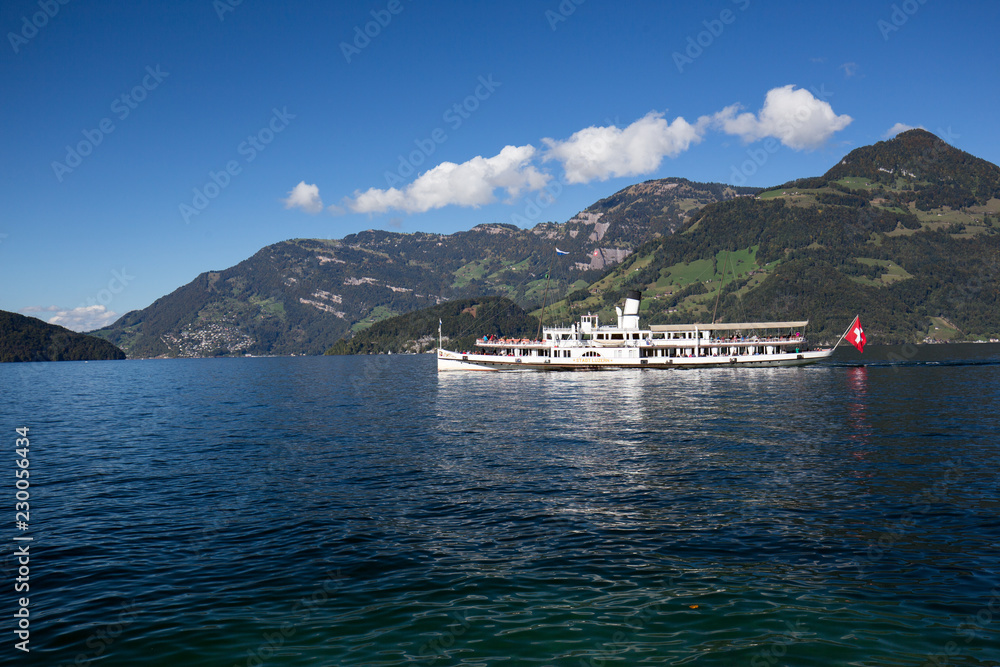 Obraz premium White boat with passengers on a lake in Switzerland