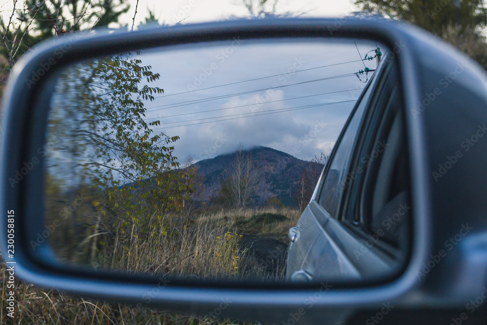 reflection of the mountain in the car mirror