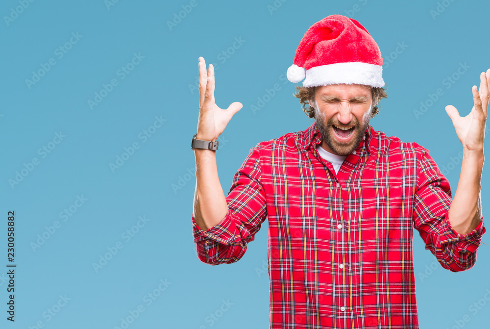 Handsome hispanic man model wearing santa claus christmas over isolated background celebrating mad and crazy for success with arms raised and closed eyes screaming excited. Winner concept Handsome hispanic man model wearing santa claus christmas over isolated background celebrating mad and crazy for success with arms raised and closed eyes screaming excited. Winner concept