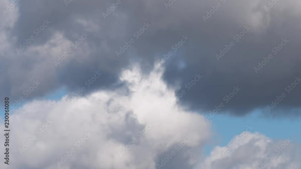 Time Lapse - beautiful white and grey fluffy clouds soar over a deep blue background. Cloudscape with autumn dark storm clouds moving fast over blue sky day - close-up. Time Lapse - beautiful white and grey fluffy clouds soar over a deep blue background. Cloudscape with autumn dark storm clouds moving fast over blue sky day - close-up.