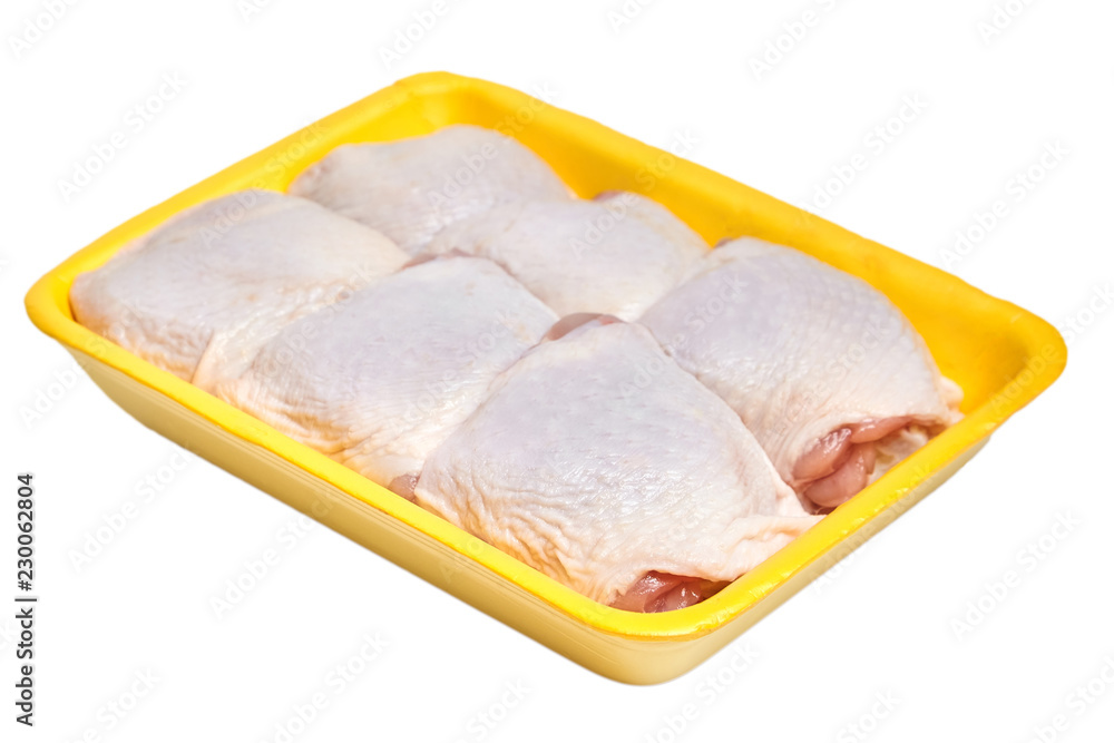 Raw chicken thighs with skin in a yellow plastic tray. Isolated on white background Raw chicken thighs with skin in a yellow plastic tray. Isolated on white background