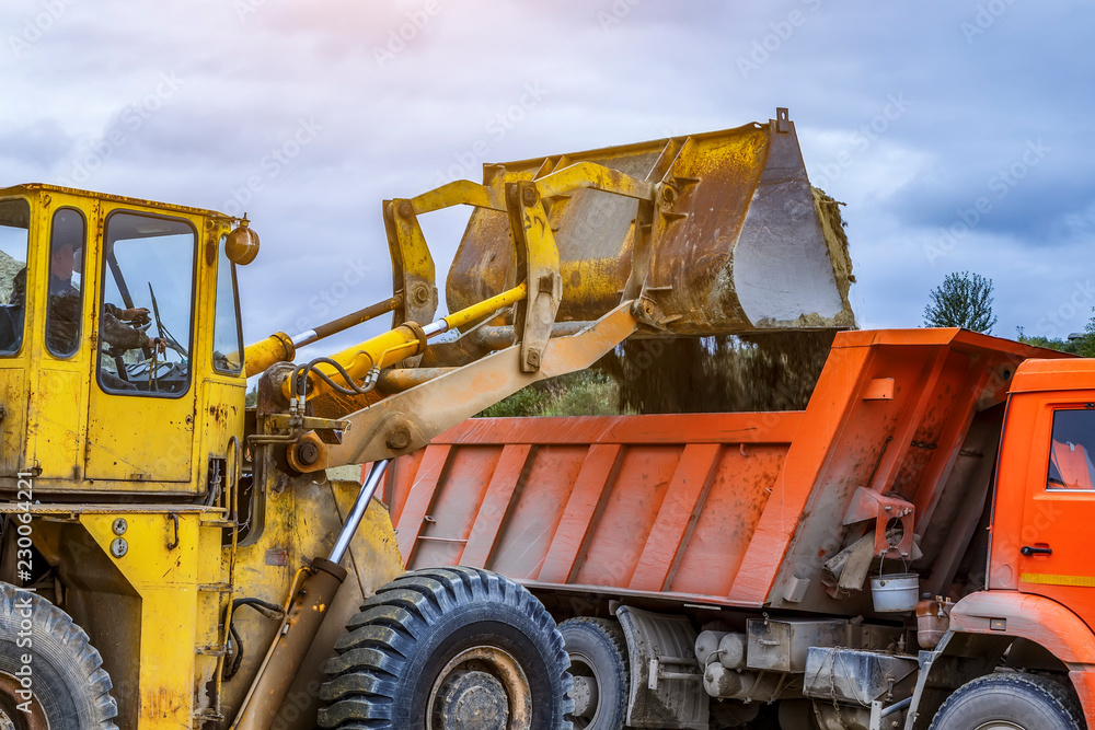 Wheel loader excavator with backhoe unloading clay Wheel loader excavator with backhoe unloading clay