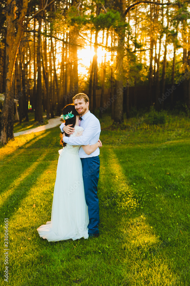 Couple of newlyweds standing on a green grass Couple of newlyweds standing on a green grass