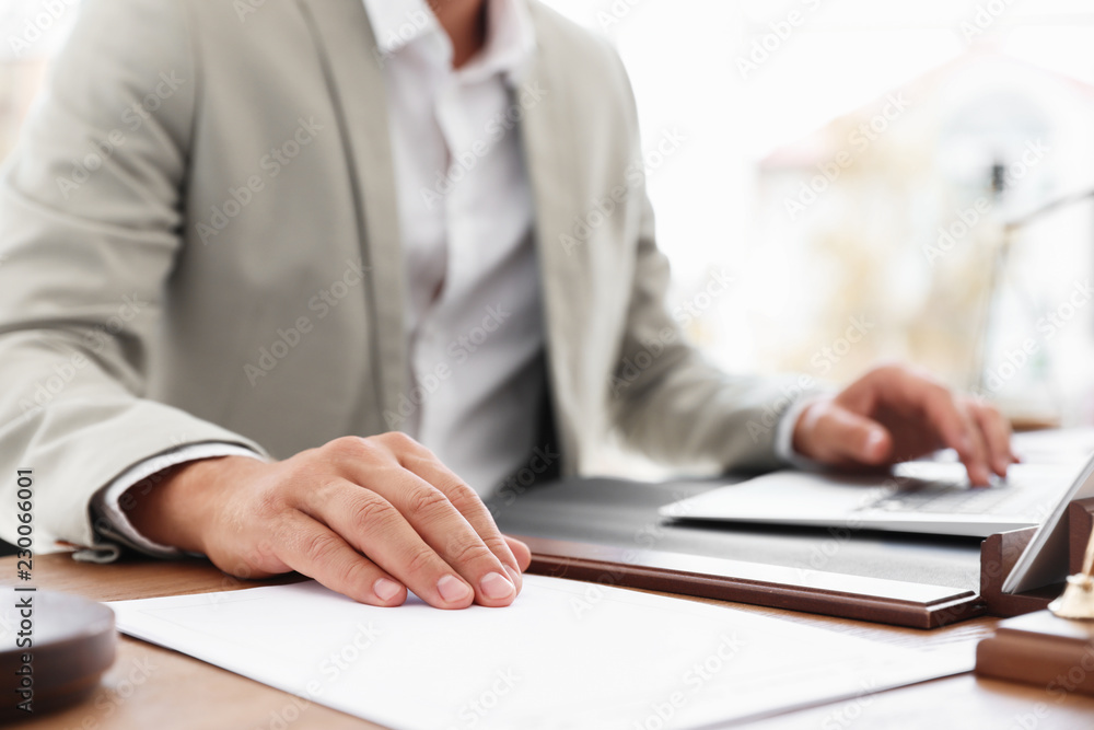 Male notary working with laptop at table in office, closeup Male notary working with laptop at table in office, closeup
