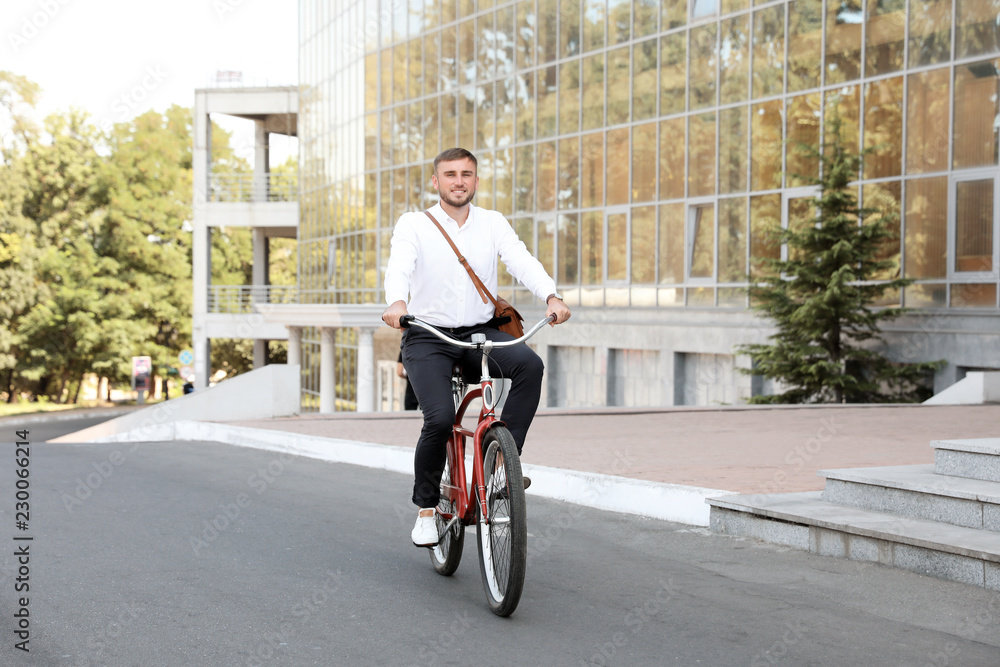 Attractive man riding bike on city street