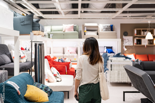 Принти на полотні Young woman choosing furniture in a modern home furnishings store