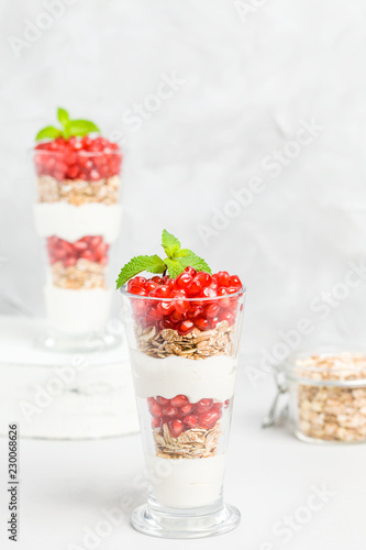 Pomegranate parfait - sweet organic layered dessert with granola flakes  yogurt and ripe fruit seeds.