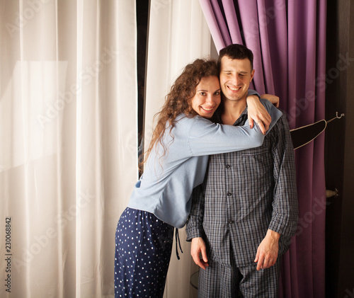 Happy couple bonding at home. Young couple hugging. Couple in pajamas in a hotel room