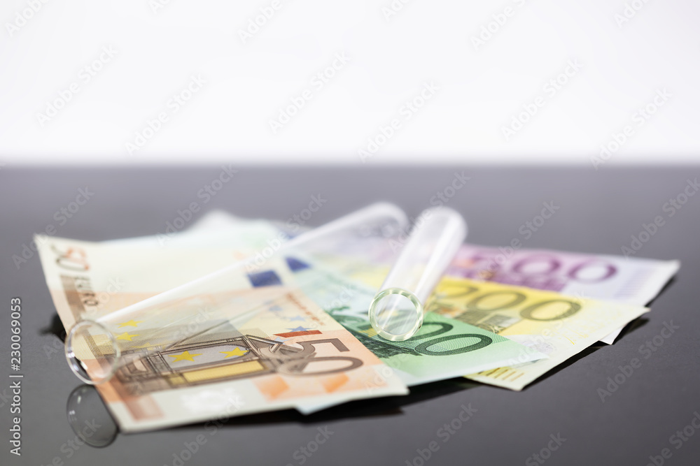 Mehrere Dollarscheine mit Reagenzgläsern, Konzepte wie teure Medizin, gesetzliche oder private Krankenkasse oder hohe Studiengebühren Mehrere Dollarscheine mit Reagenzgläsern, Konzepte wie teure Medizin, gesetzliche oder private Krankenkasse oder hohe Studiengebühren