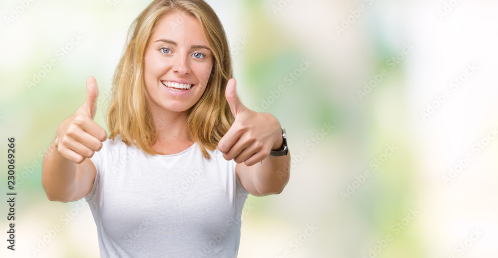 Beautiful young woman wearing casual white t-shirt over isolated background approving doing positive gesture with hand, thumbs up smiling and happy for success. Looking at the camera, winner gesture. Beautiful young woman wearing casual white t-shirt over isolated background approving doing positive gesture with hand, thumbs up smiling and happy for success. Looking at the camera, winner gesture.
