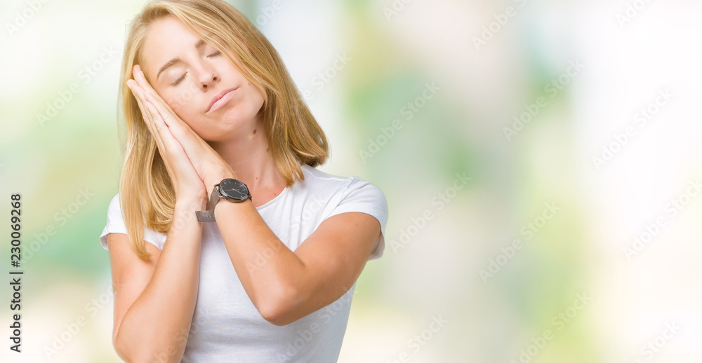 Beautiful young woman wearing casual white t-shirt over isolated background sleeping tired dreaming and posing with hands together while smiling with closed eyes. Beautiful young woman wearing casual white t-shirt over isolated background sleeping tired dreaming and posing with hands together while smiling with closed eyes.