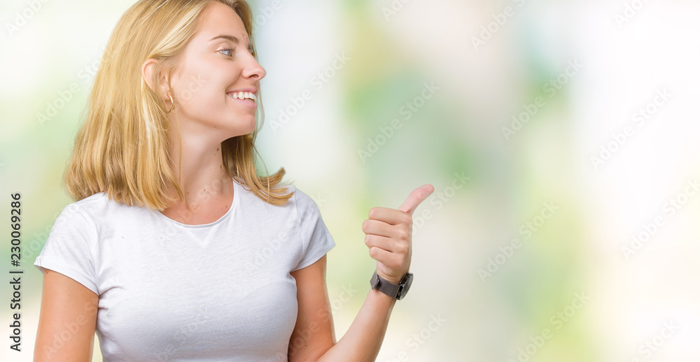 Beautiful young woman wearing casual white t-shirt over isolated background Looking proud, smiling doing thumbs up gesture to the side Beautiful young woman wearing casual white t-shirt over isolated background Looking proud, smiling doing thumbs up gesture to the side