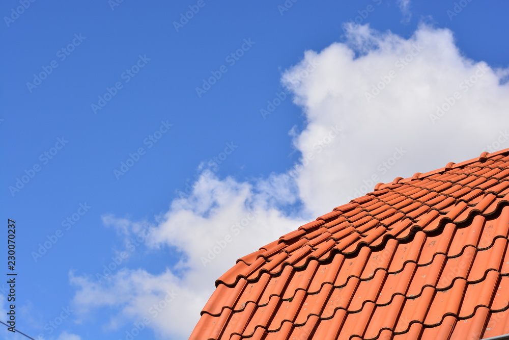 Orange tiles of a barn in Holland with a blue sky as background Orange tiles of a barn in Holland with a blue sky as background