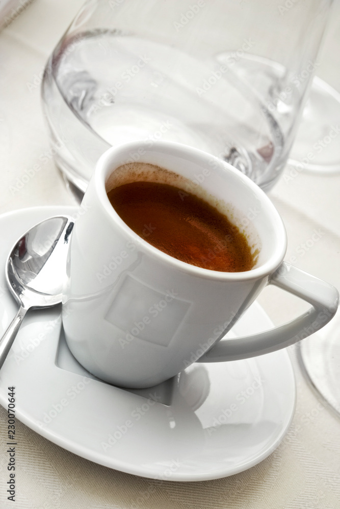 Cup of coffee on a white tablecloth Cup of coffee on a white tablecloth