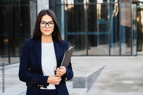 Portrait of young successful businesswoman wearing glasses and looking to camera, professional female manager in corporate suit. Student girl, wage worker, weekdays concept.