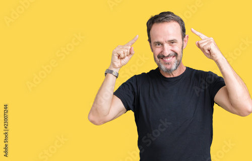 Handsome middle age hoary senior man over isolated background Smiling pointing to head with both hands finger, great idea or thought, good memory photo