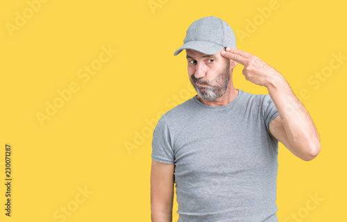 Handsome middle age hoary senior man wearing sport cap over isolated background Shooting and killing oneself pointing hand and fingers to head, suicide gesture.