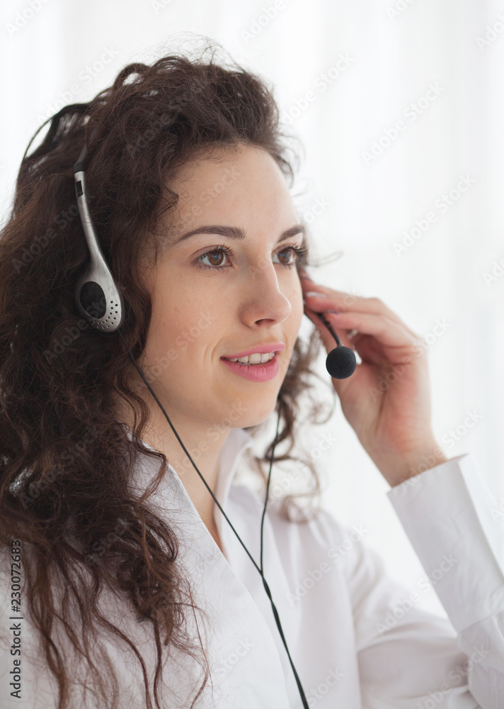 Portrait of young beautiful smiling call center worker talking to someone. Smiling customer support operator at work. Help and support or distant education concept. Portrait of young beautiful smiling call center worker talking to someone. Smiling customer support operator at work. Help and support or distant education concept.