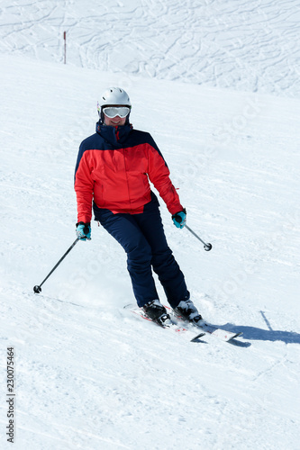 Female skier in downhill slope. Winter sport recreational activity