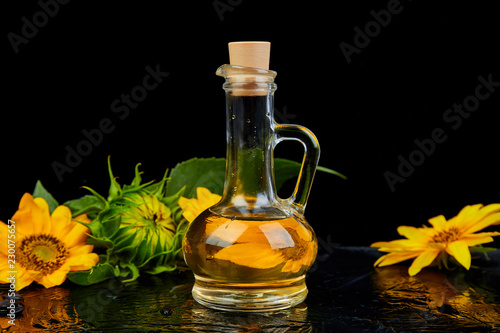 Sunflower oil in glass jar, seeds and flowers