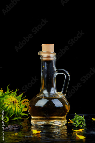 Sunflower oil in glass jar, seeds and flowers