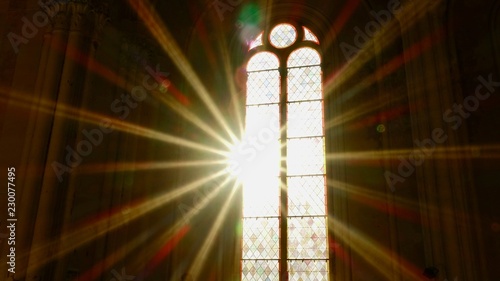 Sonnenstrahlen scheinen durch ein altes Kirchenfenster photo