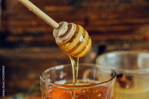 honey on a wooden spoon for honey, dripping from a spoon. Close up.