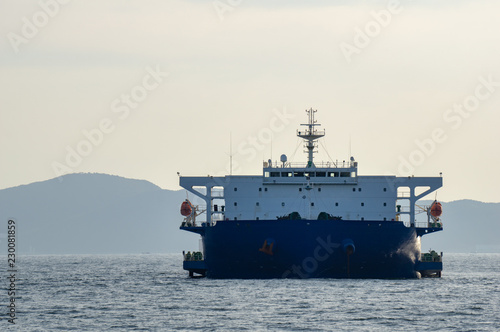 Blue and white colour project cargo ship anchors in the open sea. Project cargo ship is one of the type of Heavy-lift vessel use to carry very big size and heavy loads such as container ship.