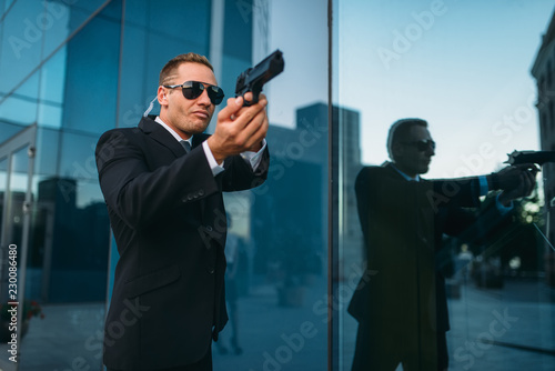 Bodyguard with security earpiece and gun in hands