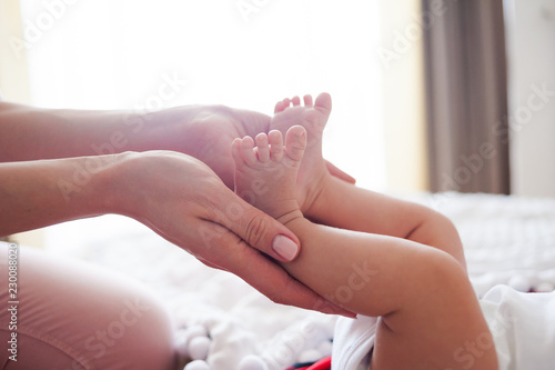 Newborn baby hands and legs mother hands