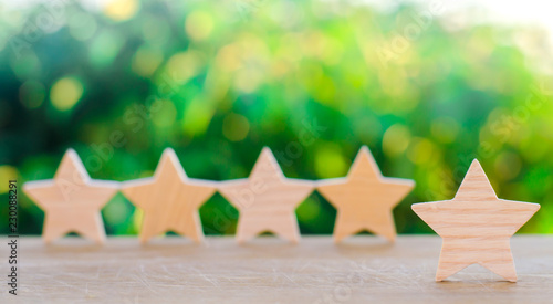 Five wooden stars. Get the fifth star. The concept of the rating of hotels and restaurants, the evaluation of critics and visitors. Quality level, good service. selective focus