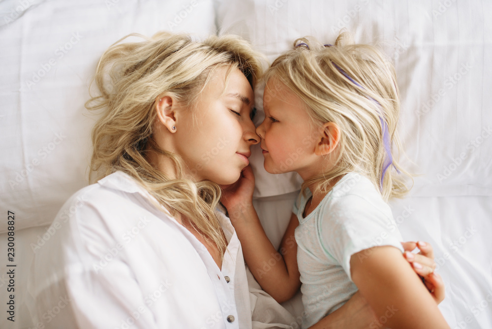 Mother and child sleeps on the bed at home Mother and child sleeps on the bed at home
