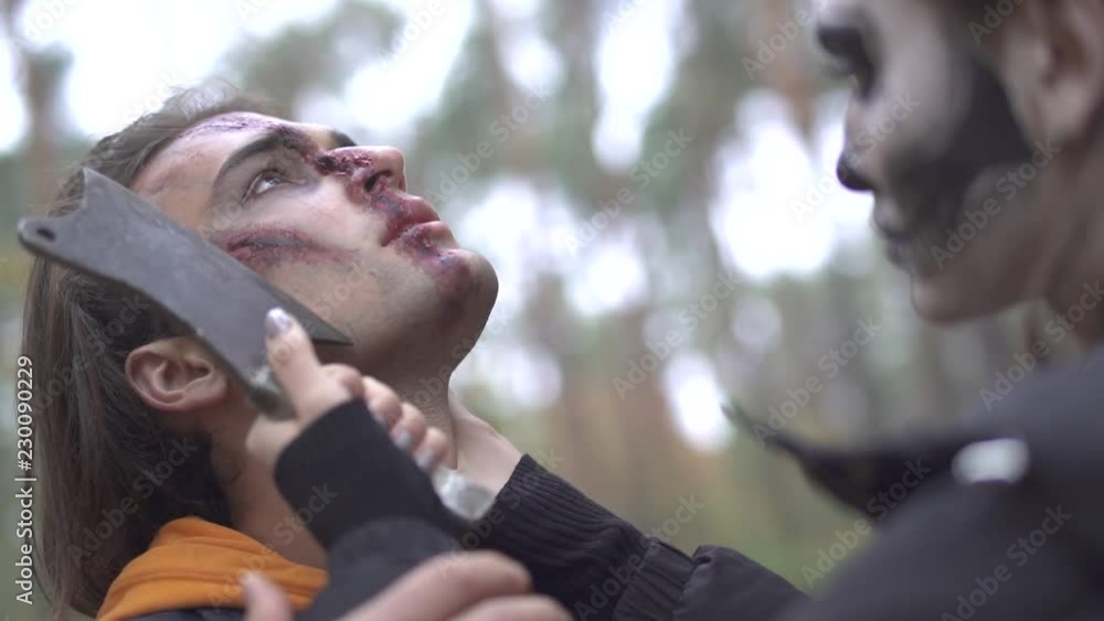Halloween. A girl with a terrible make-up threatens the guy with a knife Halloween. A girl with a terrible make-up threatens the guy with a knife