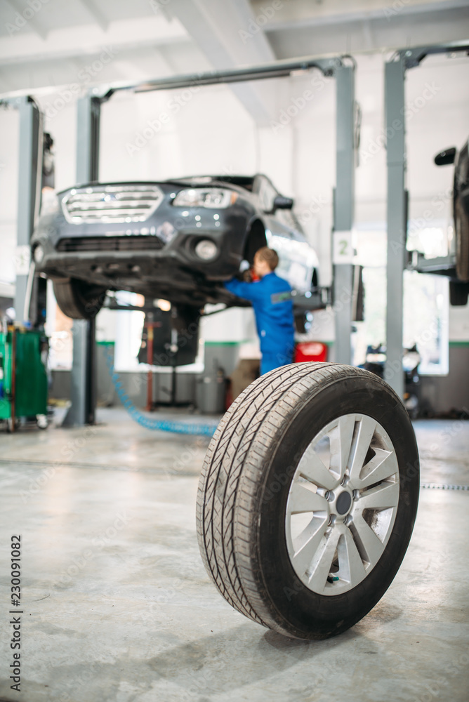 Wheel on the floor in tire service, car on lift Wheel on the floor in tire service, car on lift