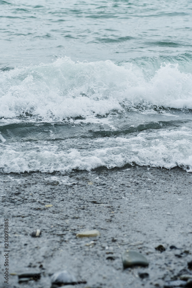 Sea wave surf crashing onto the pebble beach. Sea wave surf crashing onto the pebble beach.