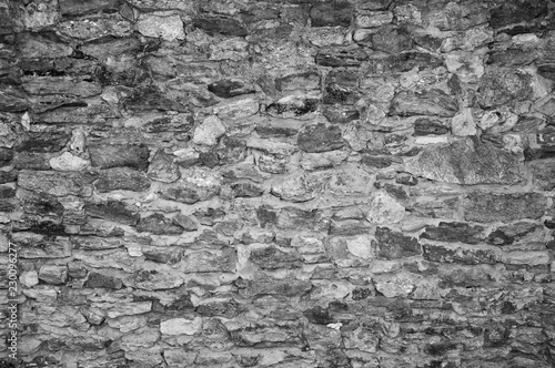 Black-and-white Texture of an old stone wall. Closeup