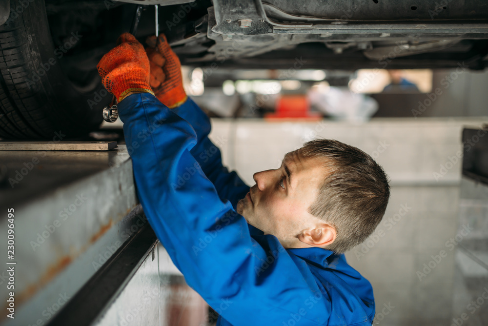Mechanic adjusts the wheel angles on stand Mechanic adjusts the wheel angles on stand