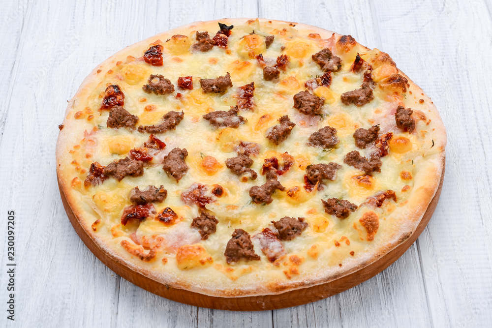 Minced meat tomato red onion pizza on a wood background. toning Minced meat tomato red onion pizza on a wood background. toning
