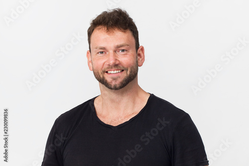 Happy, handsome young man in black smiling portrait against white background