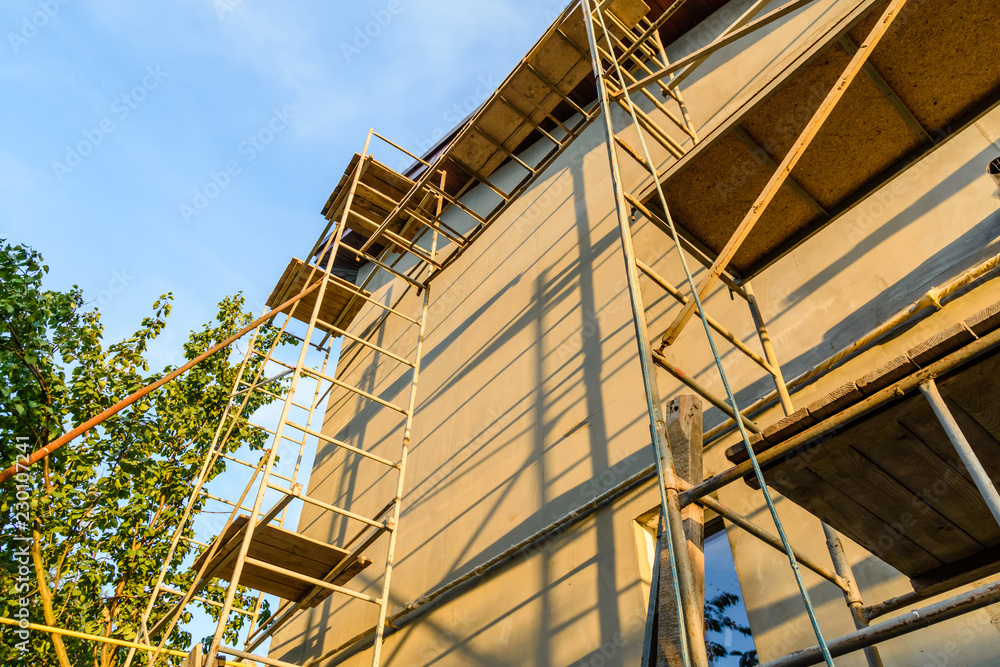 Obraz premium Insulation of the house with styrofoam. Scaffold on building