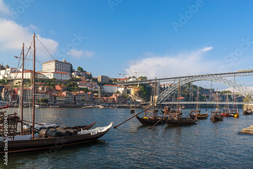 View of the Ribera and bridge Dom Luis I Bridge from Vila Nova de Gaia. The river Douro  Porto  Portugal. Colorful houses on the embankment.  Barrels of port on boats. Travel photography.