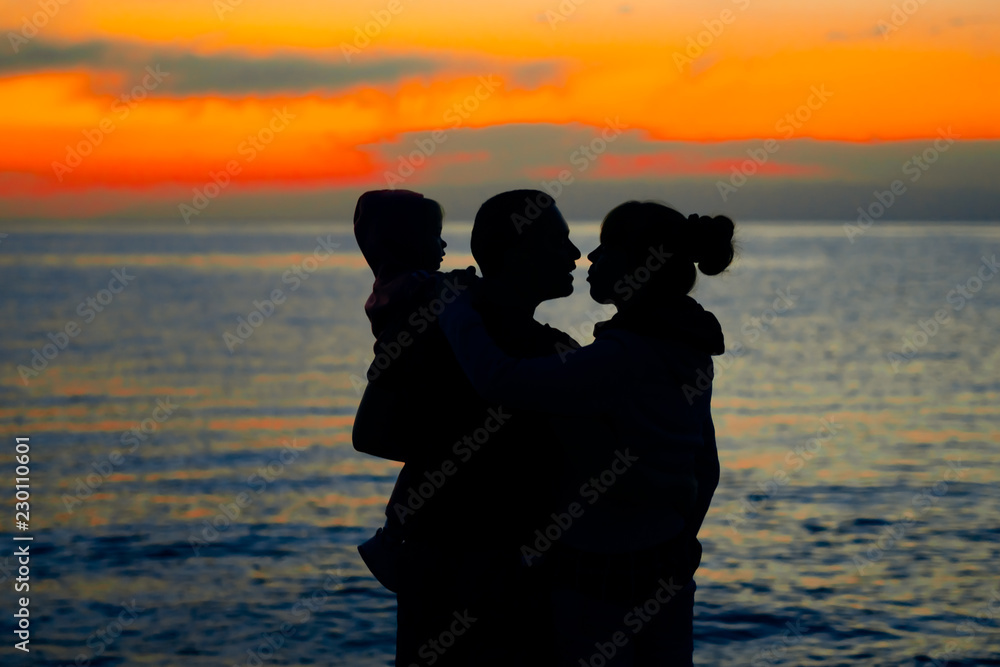 family at sunset by the sea