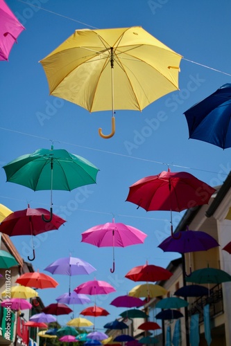ombrelli colorati appesi sopra i tetti di una città