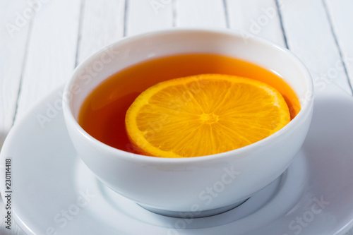 cup of tea, different leaves, honey, lemon ginger and brown sugar on white wooden table background