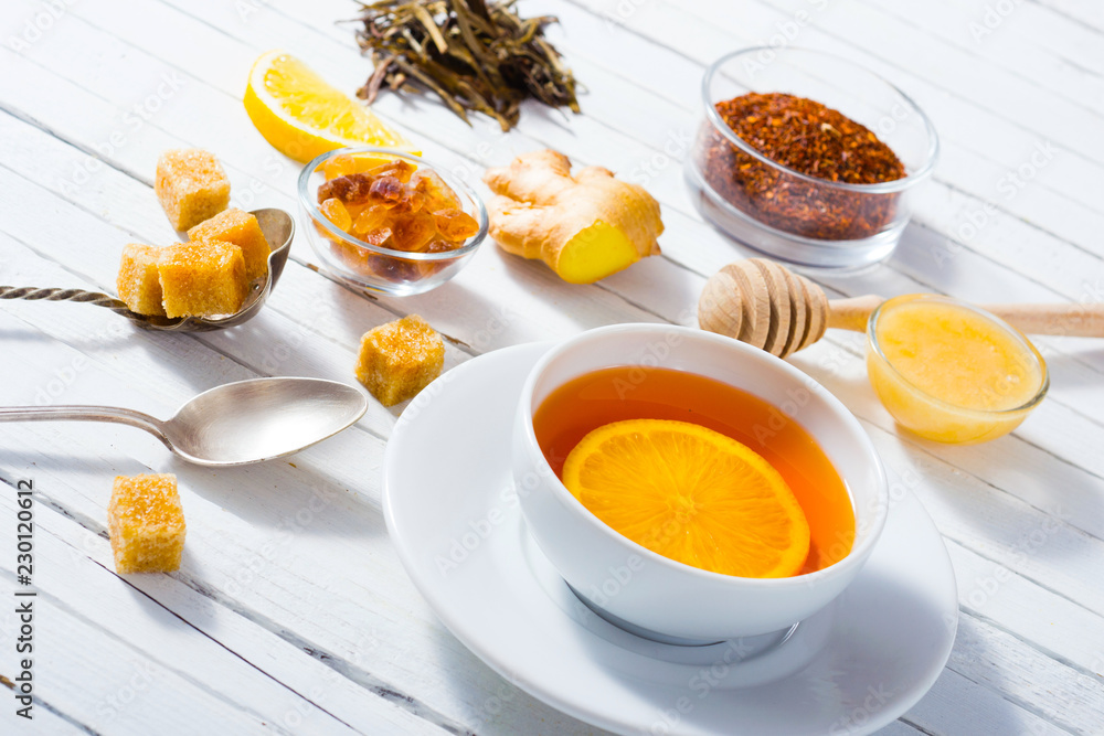 cup of tea, different leaves, honey, lemon ginger and brown sugar on white wooden table background cup of tea, different leaves, honey, lemon ginger and brown sugar on white wooden table background