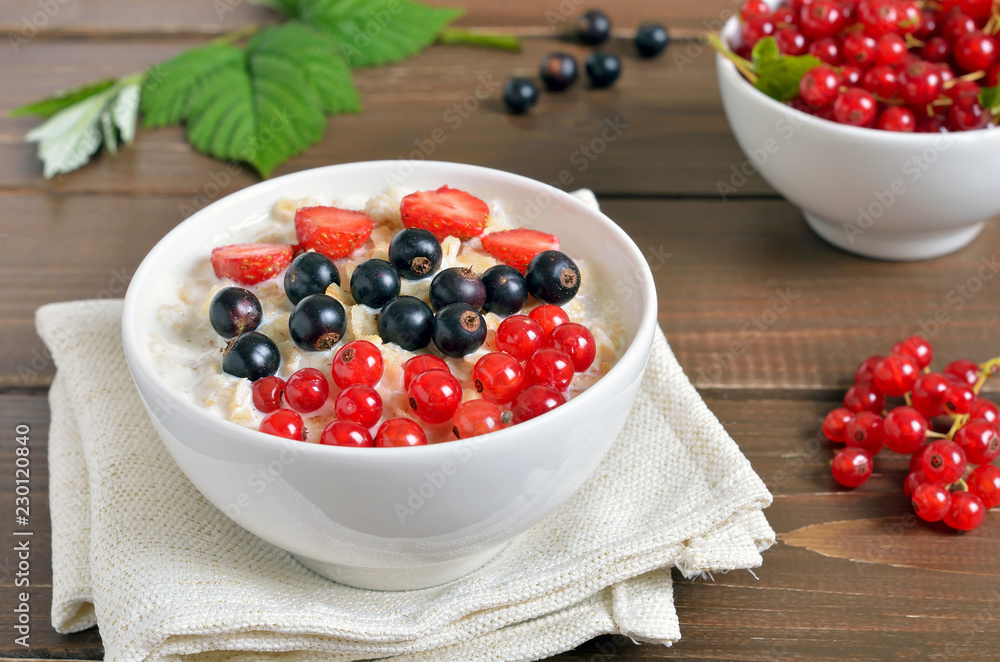 Oatmeal porridge with red and black currant and strawberry Oatmeal porridge with red and black currant and strawberry